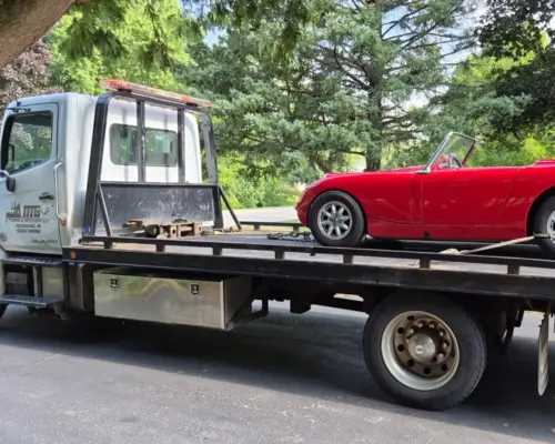 a flatbed tow truck carring a car